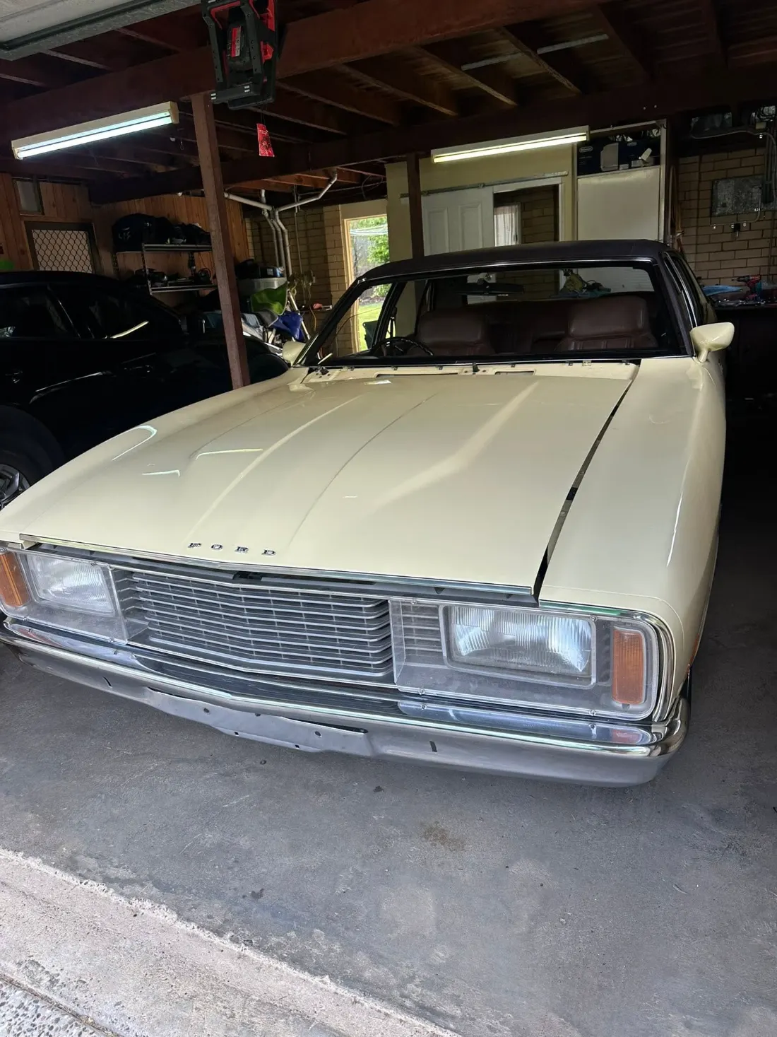 Classic Ford sedan in a home garage with the windscreen removed