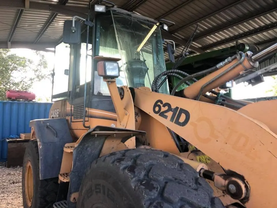 Wheel loader with new cab glass fitted under a shed