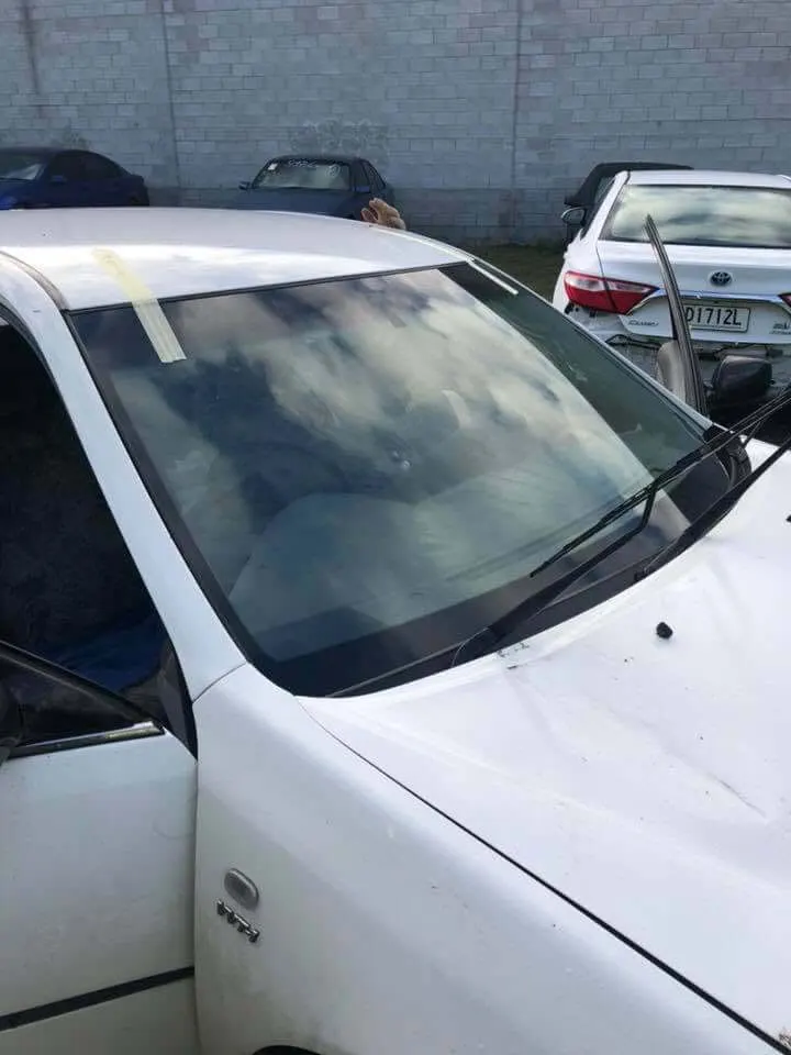 Family sedan with a newly fitted windscreen taped while the urethane cures