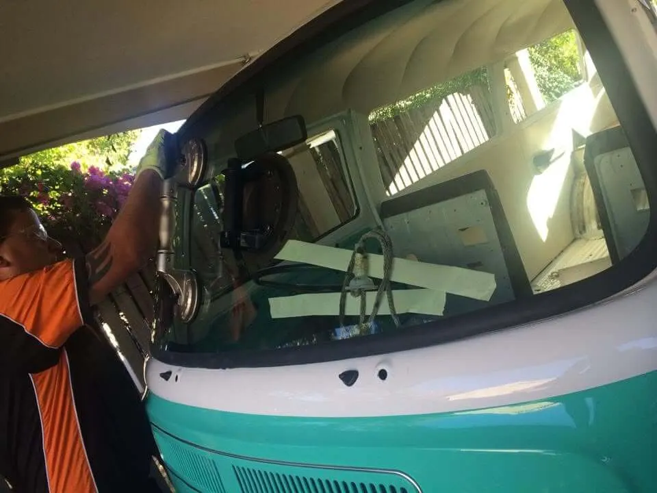 Fitter setting the windscreen on a restored classic van