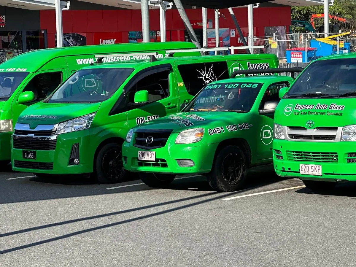 The Express Auto Glass mobile fleet — green vans and a ute parked up between jobs