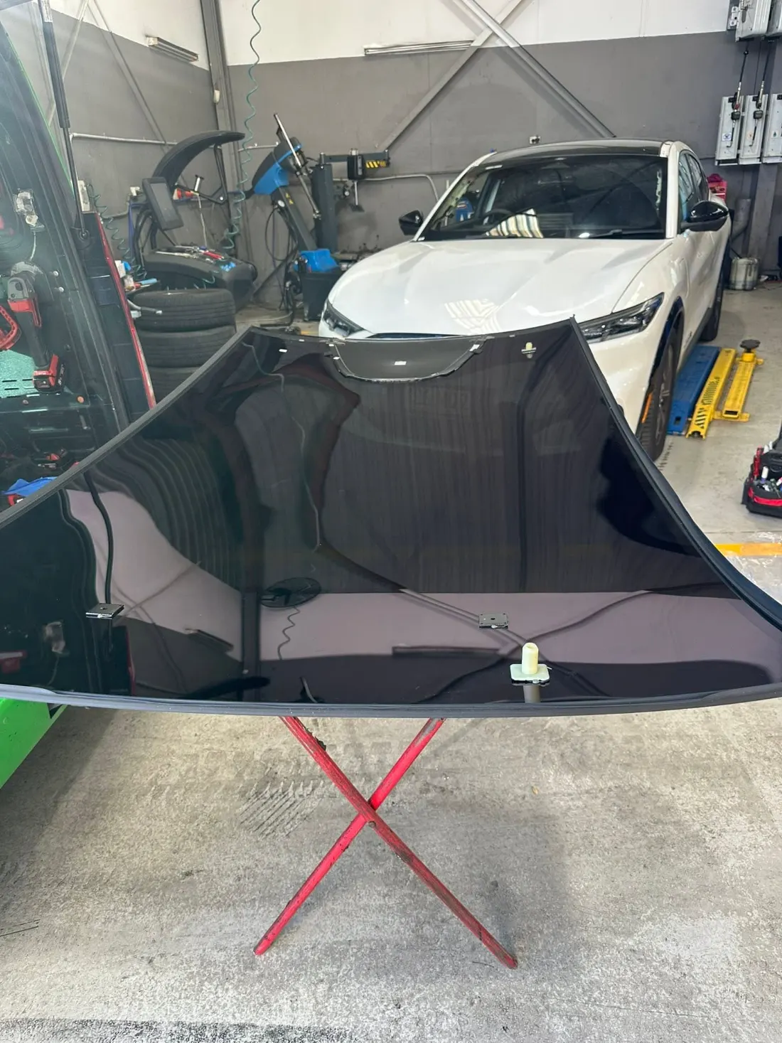 Windscreen being fitted to a car on the hoist in the workshop