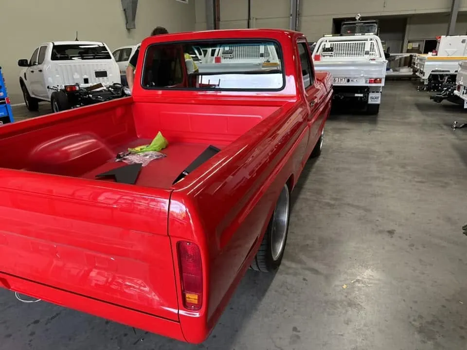Hot rod pickup outside the workshop waiting on glass
